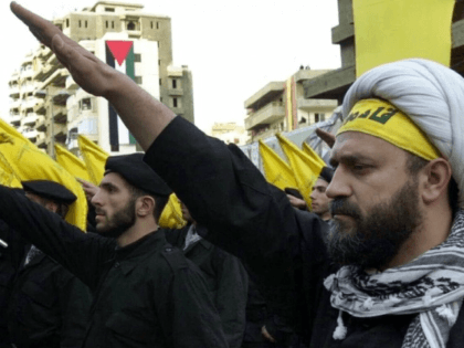 Hezbollah fighters take an oath during a parade to continue the path of resistance towards