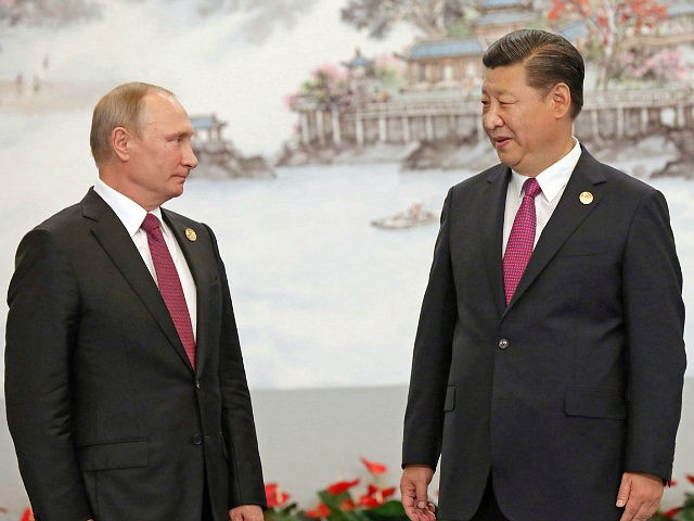 Russian President Vladimir Putin (L) and Chinese President Xi Jinping attend a photo sessi
