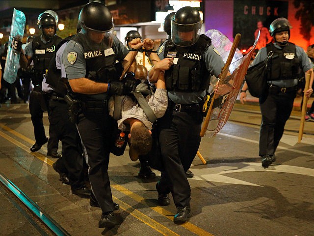 Police officers arrest a man during the later protest on Delmar Boulevard in University Ci