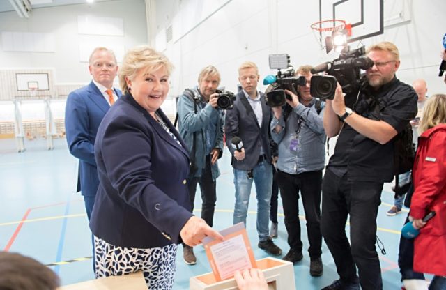 Norway's Prime Minister Erna Solberg cast her ballot flanked by her husband Sindre Finnes