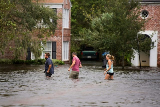 People wade through the flooded streets of the San Marco historic district of Jacksonville