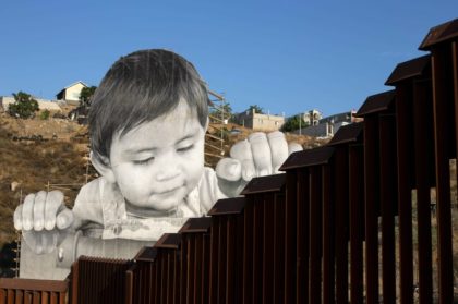 One-year-old Kikito peers over the wall at the US-Mexico border