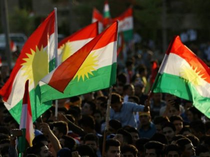 Iraqi Kurds fly Kurdish flags as they urge people to vote in a September 25 independence r