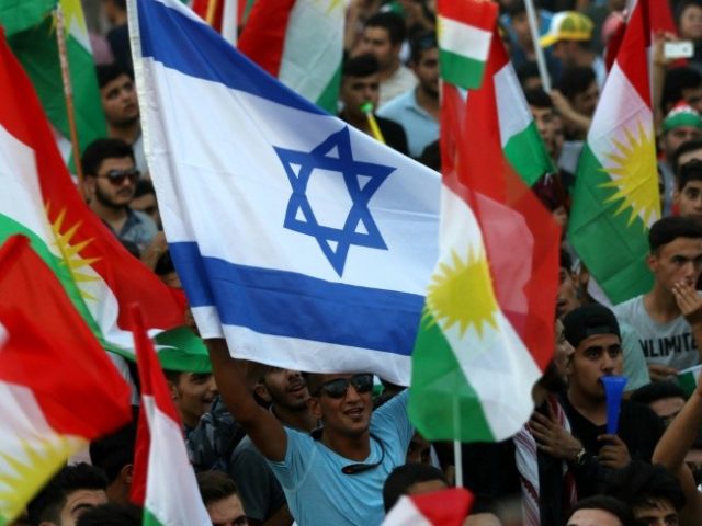 An Israeli flag is waved alongside Kurdish flags during an event in Iraqi Kurdistan's capital of Arbil to urge people to vote in a September 25 independence referendum