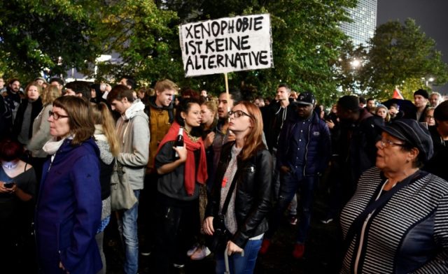 A protester holds up a sign reading "Xenophobia is not an alternative" during a protest ag