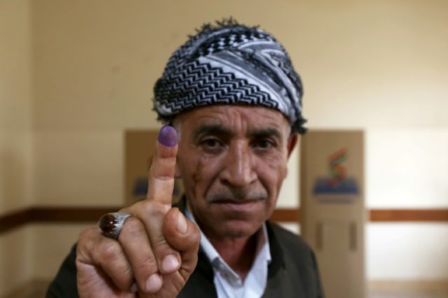 An Iraqi Kurd shows off his ink-stained finger after voting on Iraqi Kurdistan's independe
