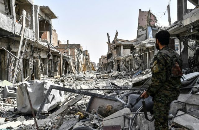 A member of the Syrian Democratic Forces surveys the destruction in the old city centre on