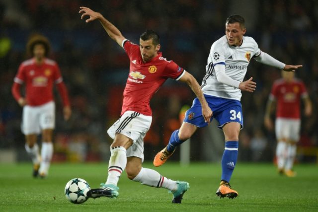Manchester United's Henrikh Mkhitaryan (L) fights for the ball with Basel's Taulant Xhaka