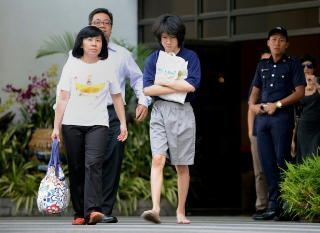 Teenage blogger Amos Yee (C), seen here with his mother and father as he walks out of a Si