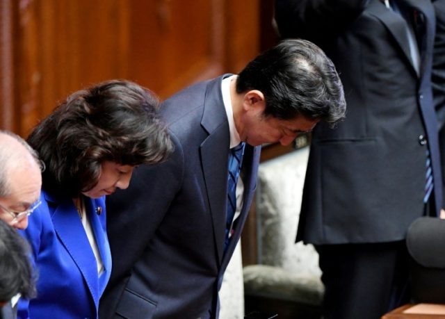 Japanese Prime Minister Shinzo Abe (C) bows as the lower house of the parliament approved