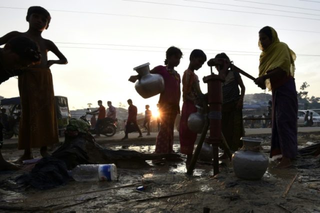 Rohingya refugees pump water at the refugee camp of Thwangkhaneari near the Bangladeshi lo