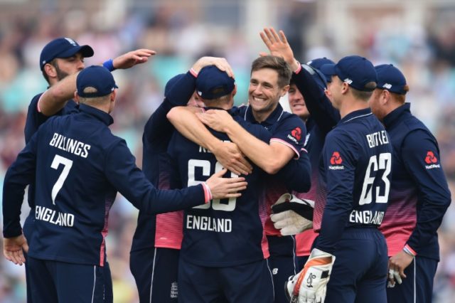 England's Chris Woakes (centre) celebrates, with teammates, the wicket of West Indies' Chr