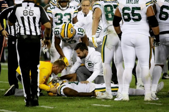 Davante Adams of the Green Bay Packers is attended to after being injured in the third qua