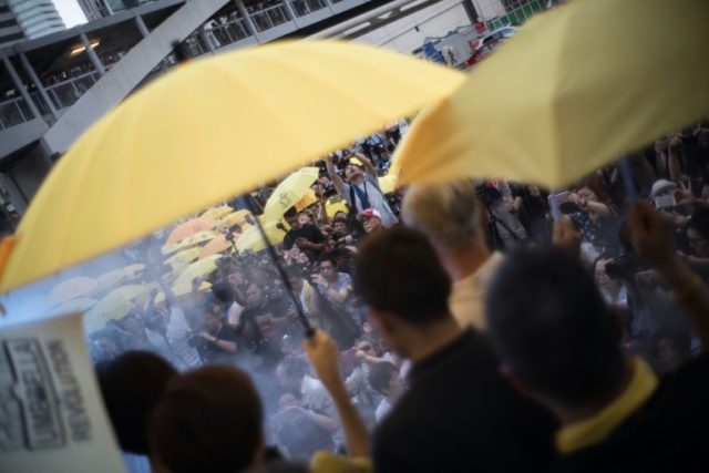 Hundreds of people raised yellow umbrellas at 5:58pm (0958 GMT) Thursday as smoke was gene