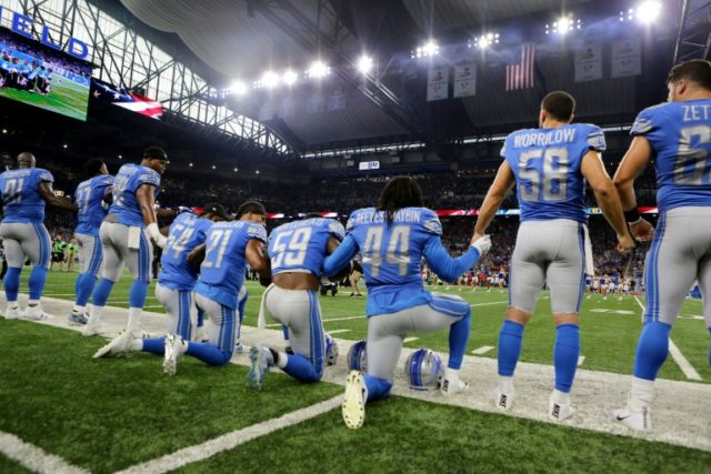Members of the Detroit Lions take a knee during the playing of the national anthem on Sept