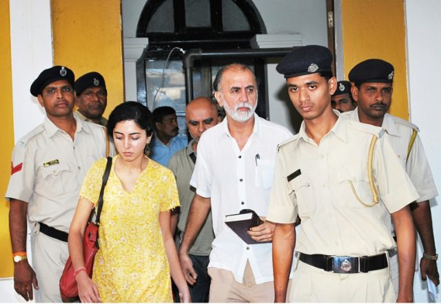 Indian magazine editor Tarun Tejpal (C) is escorted by police officials after a hearing at