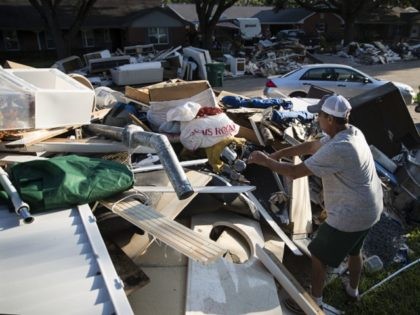 Steve Blatt helps a neighbor to retrieve an item from a debris pile in the aftermath of Hurricane Harvey on Wednesday, Sept. 6, 2017, in Houston. (AP Photo/Matt Rourke)