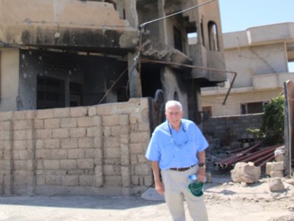 Former Rep. Frank Wolf (R-VA) stands in front of the ruins of a Christian community in Ira