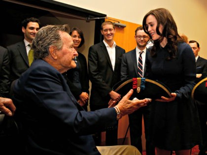 Former President George H.W. Bush, left, receives a tri-corner hat from actress Heather Lind, right, at a private screening of AMC's new series TURN on Saturday, March, 29, 2014 in Houston, Texas. (Photo by Aaron M. Sprecher/Invision for AMC/AP Images)