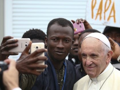 Pope Francis poses for a selfie with a man as he visits a migrant reception centre during a pastoral visit in Bologna, on October 1, 2017. / AFP PHOTO / POOL / ALESSANDRO BIANCHI (Photo credit should read ALESSANDRO BIANCHI/AFP/Getty Images)