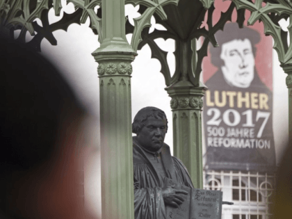 Visitors walk in front of the Martin Luther monument prior the celebrations on the occasion the 500th Anniversary of the Reformation in Wittenberg, Germany, Tuesday, Oct. 31, 2017. German will leaders mark the 500th anniversary of the day Martin Luther is said to have nailed his theses challenging the Catholic …