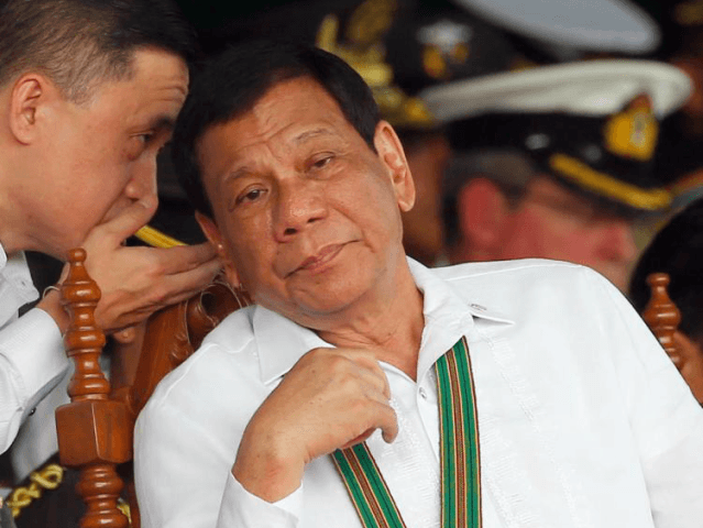 FILE - In this Oct. 5, 2017 file photo, Philippine President Rodrigo Duterte, right, liste