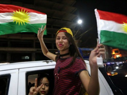 Iraqi Kurds wave the Kurdish flag as they celebrate the independence referendum in the str