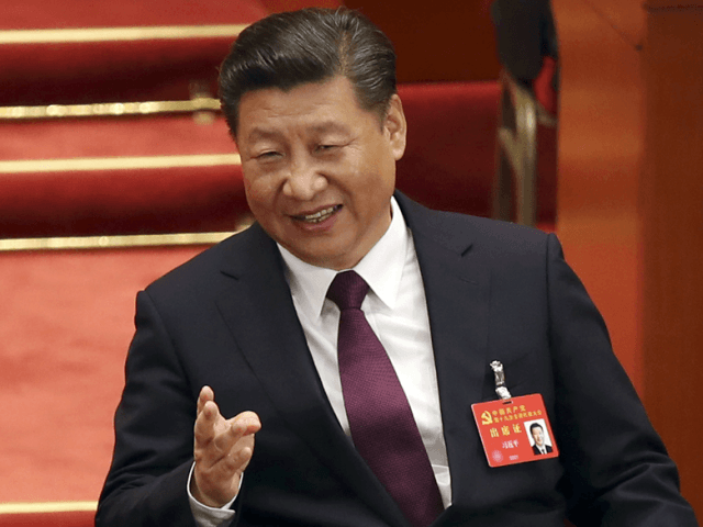 FILE - In this Oct. 18, 2017 file photo, Chinese President Xi Jinping talks with former Chinese President Hu Jintao during the opening session of China's 19th Party Congress at the Great Hall of the People in Beijing. China’s economic growth stayed relatively stable in the latest quarter, buoyed by …