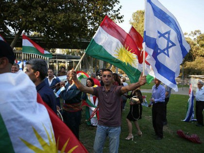 Members of the Kurdish Jewish community hold Kurdish and Israeli flags during a demonstrat