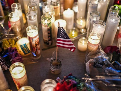 LAS VEGAS, NV - OCTOBER 3: A U.S. flag is placed in the middle of flowers and candles at a vigil that was held for the victims along the Las Vegas Strip a day after 59 people were killed and more than 500 wounded at the Route 91 Harvest Country …