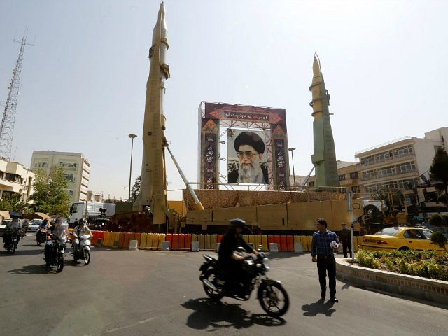 Iranians walk past Sejjil (L) and Qadr-H medium range ballistic missiles displayed next to a portrait of Iranian Supreme Leader Ayatollah Ali Khamenei on the occasion of the annual defence week which marks the anniversary of the 1980s Iran-Iraq war, on September 25, 2017, on Baharestan square in Tehran. / …