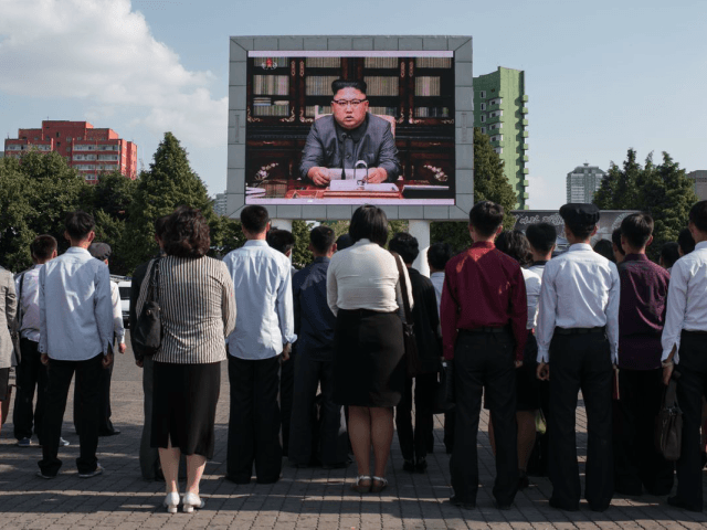 Spectators listen to a television news brodcast of a statment by North Korean leader Kim J