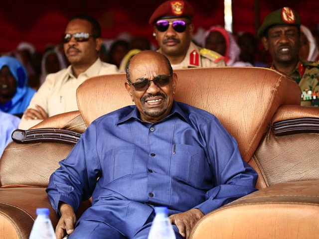 Sudanese President Omar al-Bashir sits during a visit to the village of Bilel in South Dar