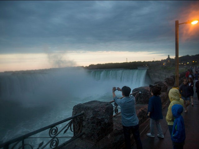 Tourists take photographs of the Horseshoe Falls in Niagara Falls, Ontario, Canada, on Wed