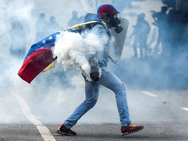 CARACAS, VENEZUELA, JULY 9: A protester with a tear gas mask and the Venezuelan flag holding a tear gas carister during clashes with the Bolivarian National Guard in a demonstration marking 100 days of protests against Venezuelan President Nicolas Maduro in Caracas, on July 9, 2017. Venezuela hit its 100th …