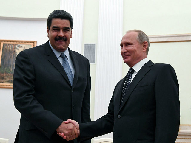 Russian President Vladimir Putin (R) shakes hands with his Venezuelan counterpart Nicolas