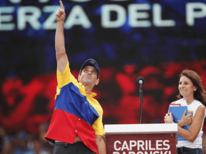 Opposition presidential candidate Henrique Capriles Radonski greets supporters with his mother, Monica Radonski, during a campaign rally in Caracas, Venezuela, on Sunday. Capriles is running against President Hugo Chavez in the country's Oct. 7 election. (photo credit: Rodrigo Abd/AP Photo)