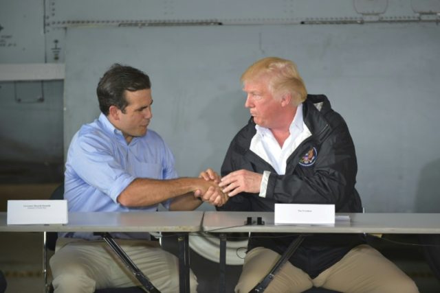 US President Donald Trump, seen here with Governor Ricardo Rossello (L), is visiting Puert