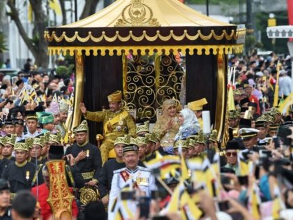 Brunei's Sultan Hassanal Bolkiah and Queen Saleha wave to crowds during Thursday's golden jubilee procession