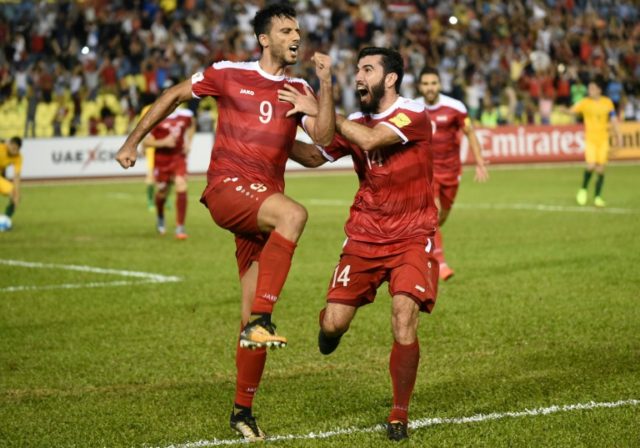 Omar Al Somah of Syria (L) celebrates a penalty goal with a teammate against Australia dur