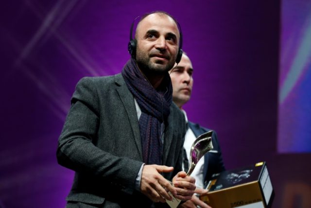 Iraqi photographer Ali Arkady receives the Photo Prize during the closing ceremony of the
