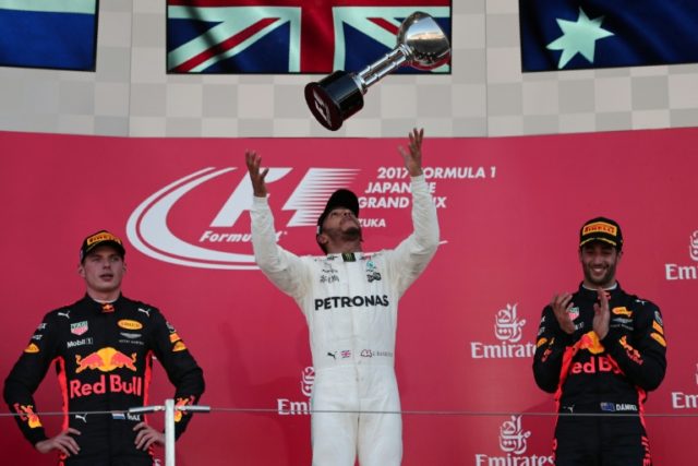 Mercedes' British driver Lewis Hamilton (centre) celebrates winning the Japanese Grand Pri