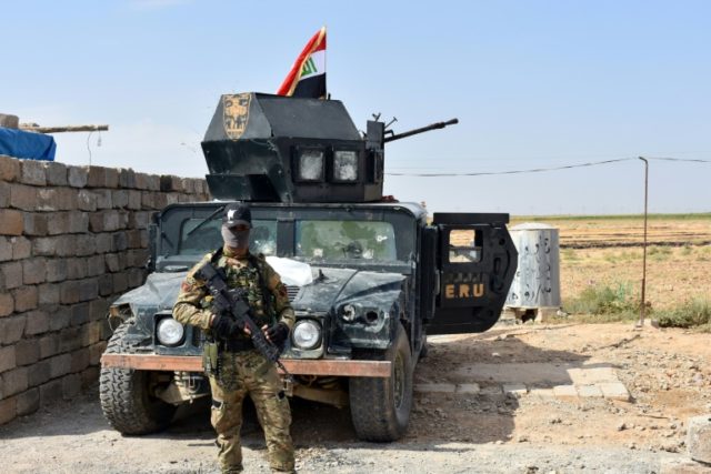 Iraqi troops guard a military position retaken from Kurdish forces in the Kirkuk province