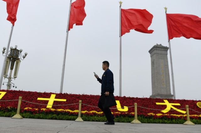 A man walks past decorations for the Communist Party's 19th Congress in Tiananmen Square,