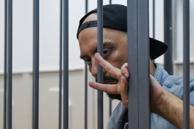 Russian theatre and film director Kirill Serebrennikov gestures from the defendants' cage