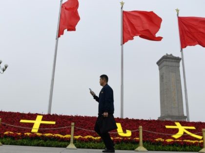A man walks past decorations for the Communist Party's 19th Congress in Tiananmen Square, on the eve of its opening