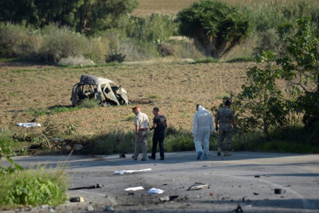 Police and investigators at the site where Malta blogger Daphne Caruana Galizia was killed