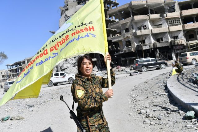 Rojda Felat, a Syrian Democratic Forces (SDF) commander, waves her group's flag at the ico
