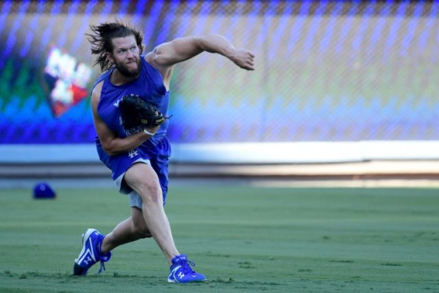 Clayton Kershaw of the Los Angeles Dodgers throws the ball in the outfield ahead of the Wo