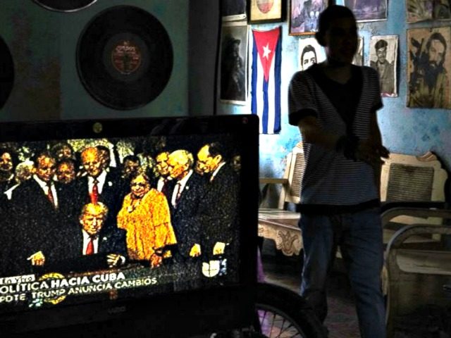 A television set shows President Donald Trump signing the new Cuba policy in a living room festooned with images of Cuban leade